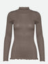 Diese Rollkragenbluse besticht durch ihre Raffinesse mit ihren gewellten Kanten an Halsausschnitt und Saum und verleiht jedem Outfit einen Hauch von Eleganz. 
